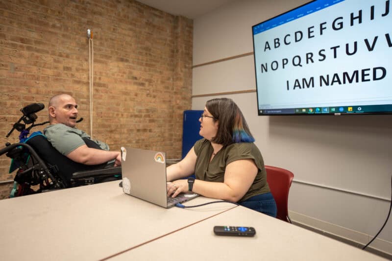 Man in wheelchair talking to a woman on a laptop