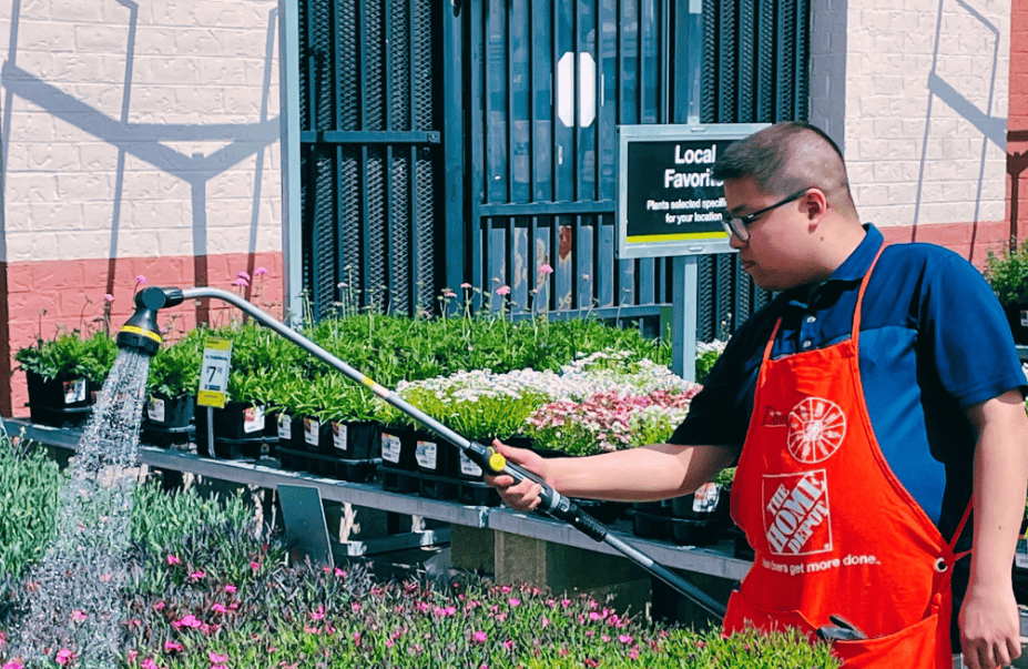 Man watering flowers at Home Depot