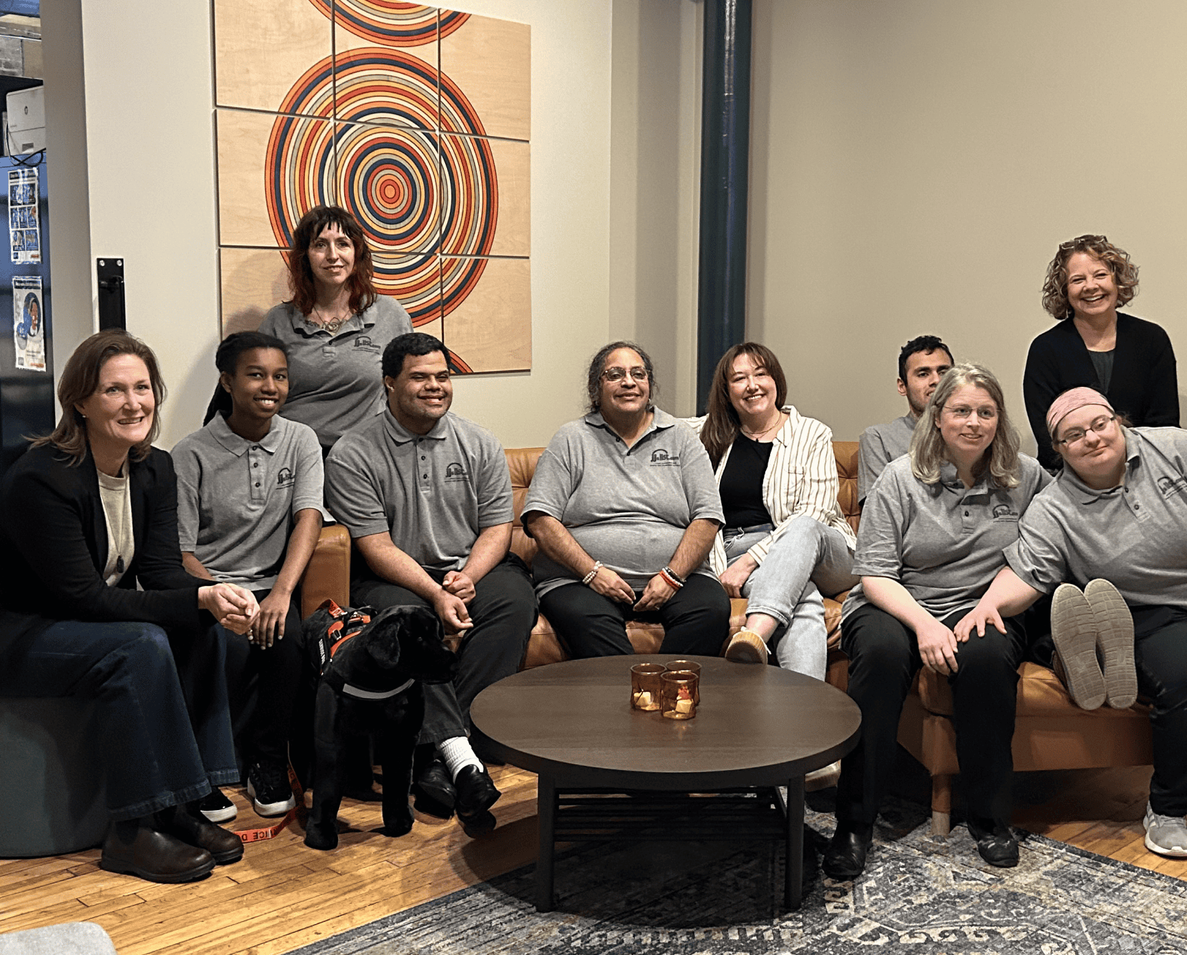 A group of people sitting on a leather couch smiling