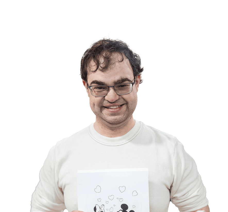 A man with curly hair, glasses and white crewneck smiling at the camera