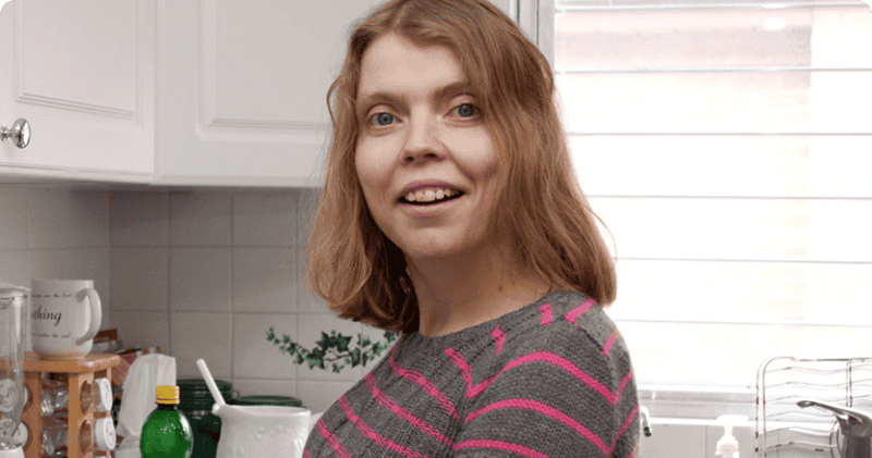 Woman in striped shirt with blonde hair smiling at camera