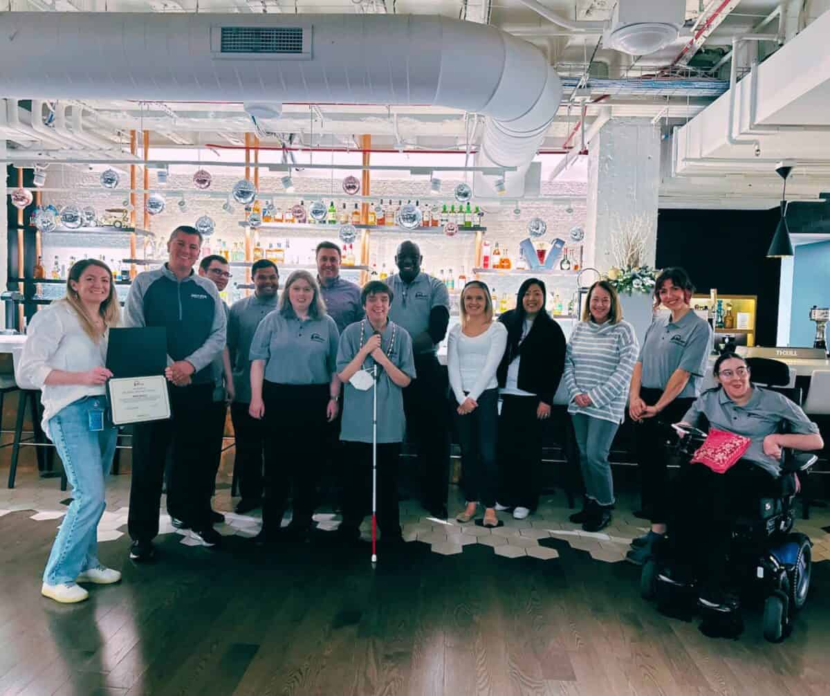 Group of smiling people. DAT players at Beam Suntory, who hosted a Disability Awareness Training.