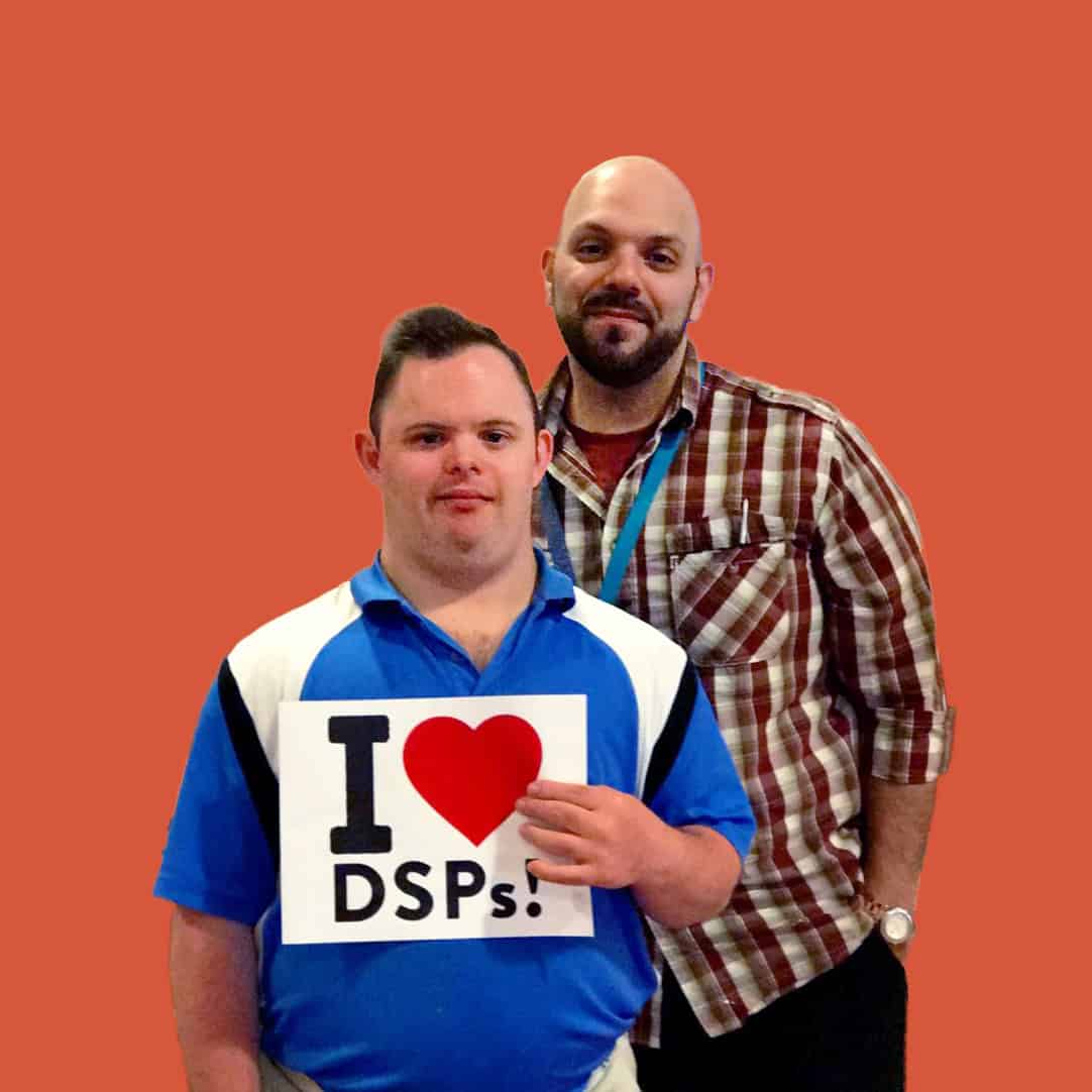 Two men, one holding an "I Heart DSPs" sign
