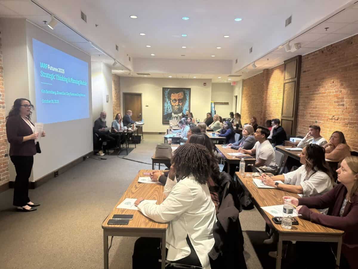 A woman presenting to a room full of people