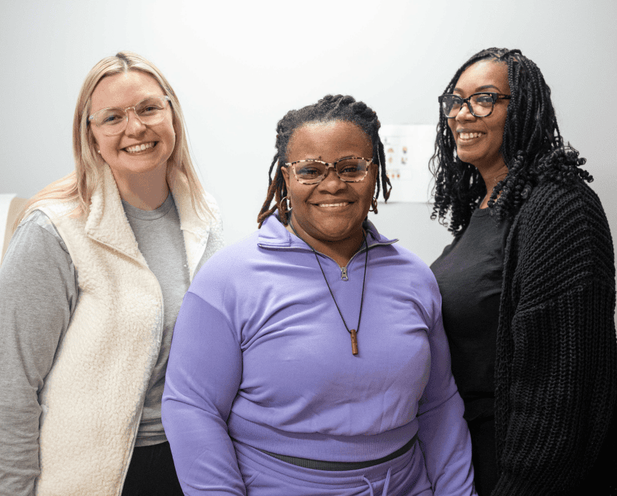 3 women wearing glasses standing next to each other smiling